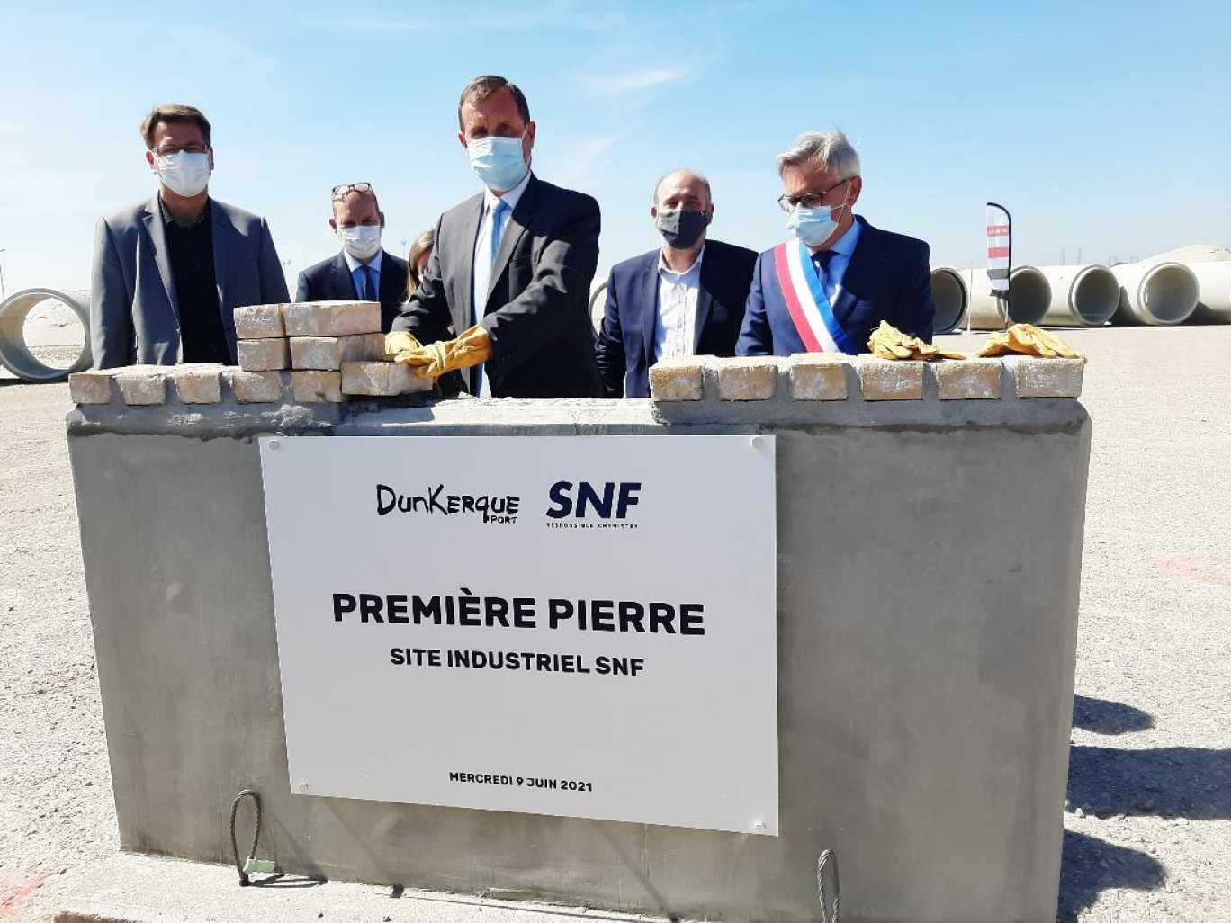 Pascal Rémy, Pdg de SNF, pose symboliquement la première pierre de la future usine du groupe en présence de personnalités locales.