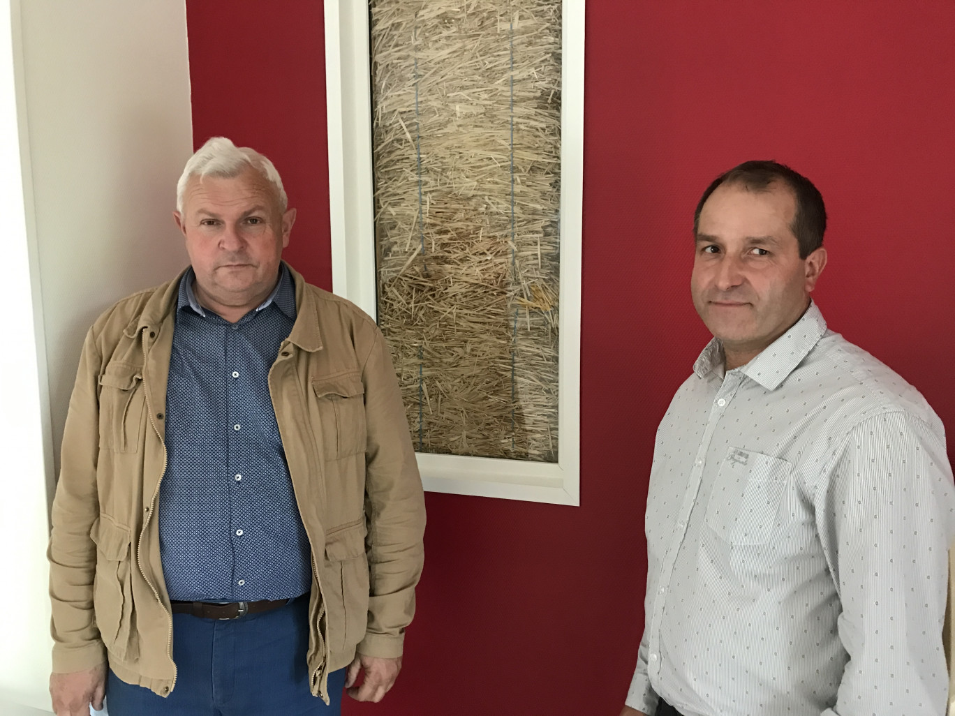 Philippe Carton, maire de Frévin-Capelle, et son adjoint Fabien Duranel devant le mur en paille de la salle des fêtes.