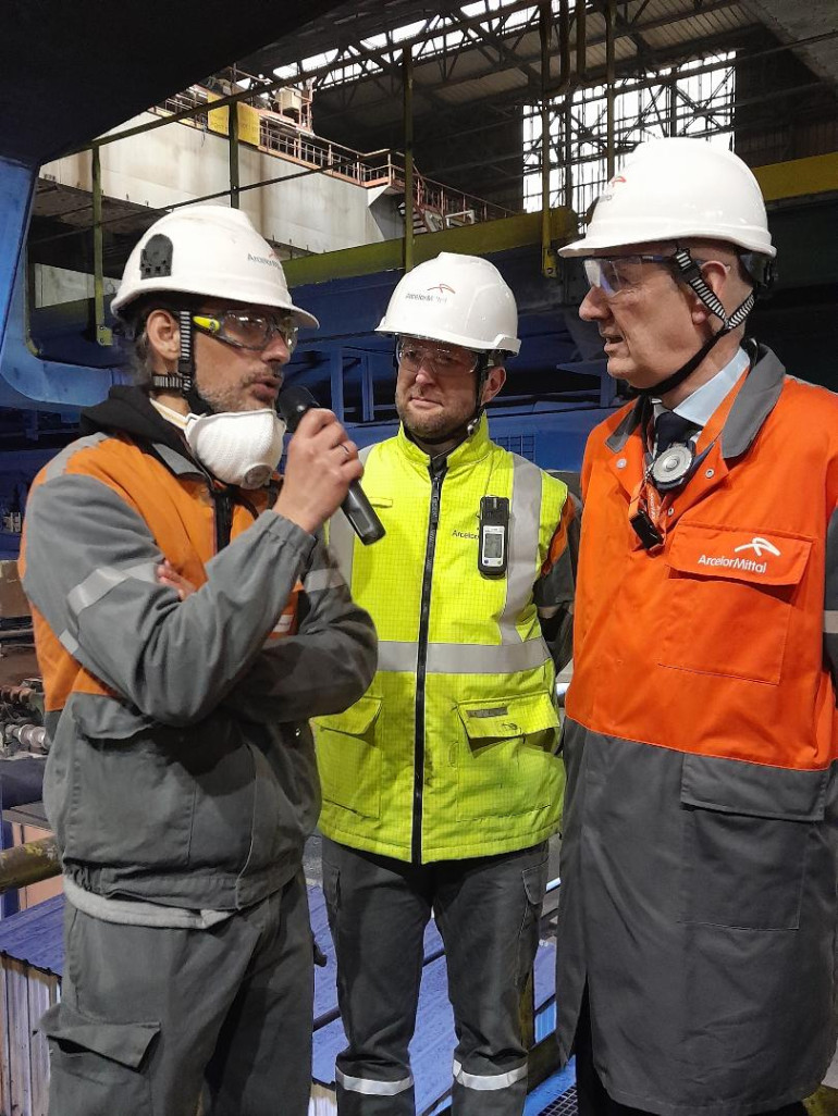 Le ministre délégué à l'Industrie, Roland Lescure, (à droite) se fait expliquer le processus de fabrication de l'acier par un jeune ingénieur lors de sa visite chez ArcelorMittal.
