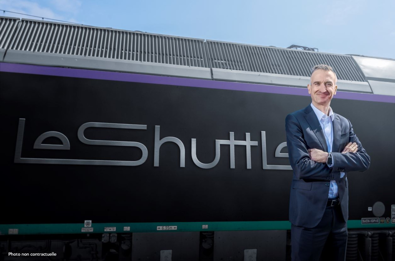 Yann Leriche, directeur général du groupe Getlink, au côté du nouveau logo du Shuttle. © Getlink
