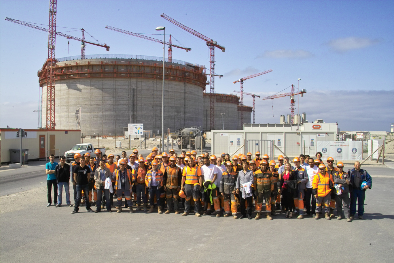 L'équipe Bouygues TP devant les trois réservoirs de GNL en construction sur le chantier du Terminal Méthanier.