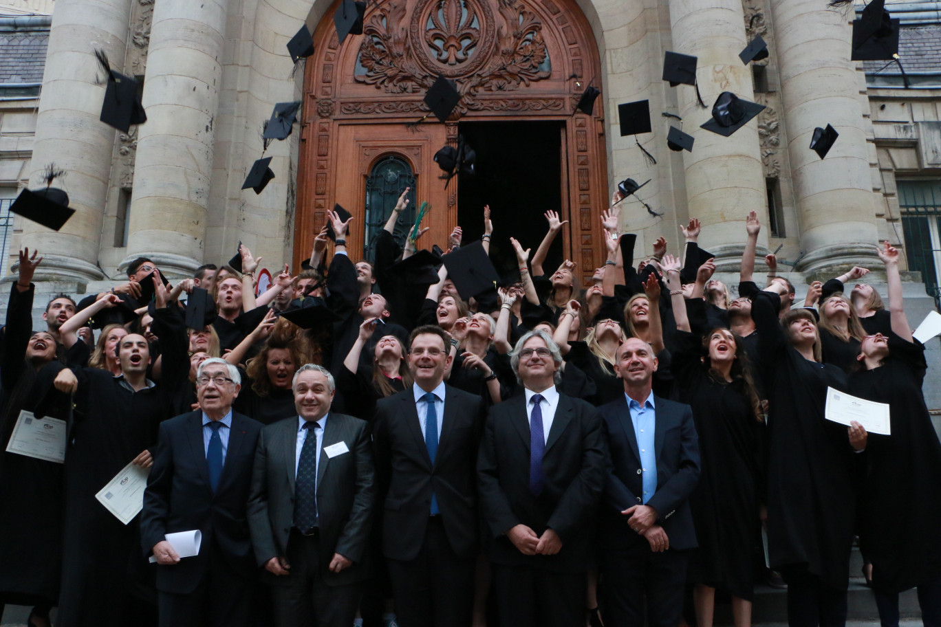 Le traditionnel lancer de chapeaux des diplômés sur le perron de la Maison de l’éducation permanente. 