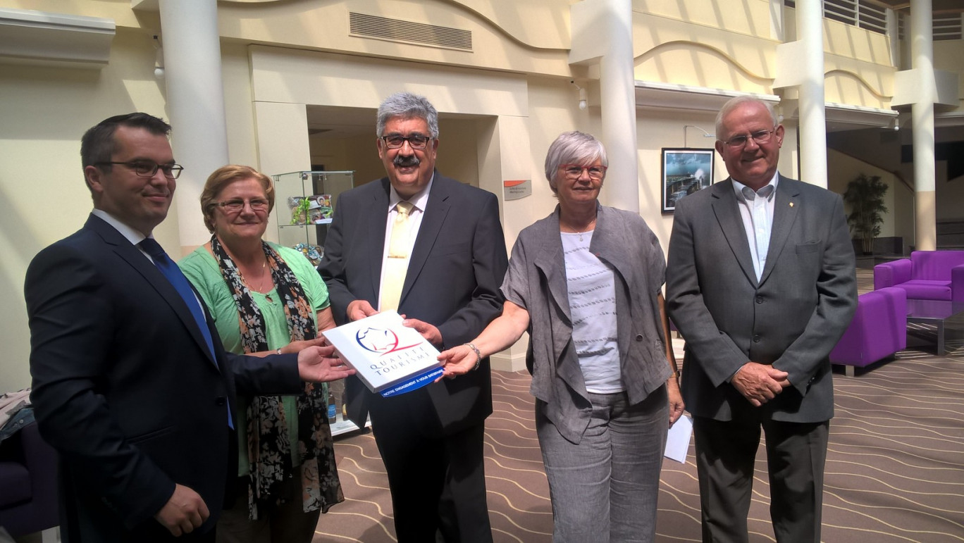 M. Samseou reçoit la plaque des mains de Nicole Heux, présidente de l'OT de Calais, de Pierre Nouchi, président syndicat des H ôteliers restaurateurs du Calaisis et de Christine Nacry.
