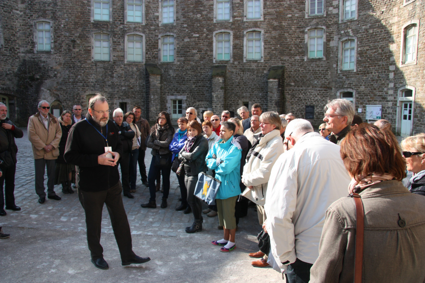 Les participants à l'éductour écoutent attentivement les explications de leur guide dans la cour du château-musée de Boulogne-sur-Mer.