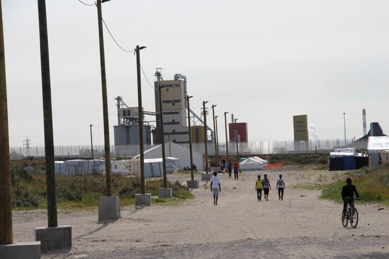« Dans la lande aux abords de la zone portuaire, le camp des migrants jouxtent également la zone d'activités industrrielles des Dunes ».