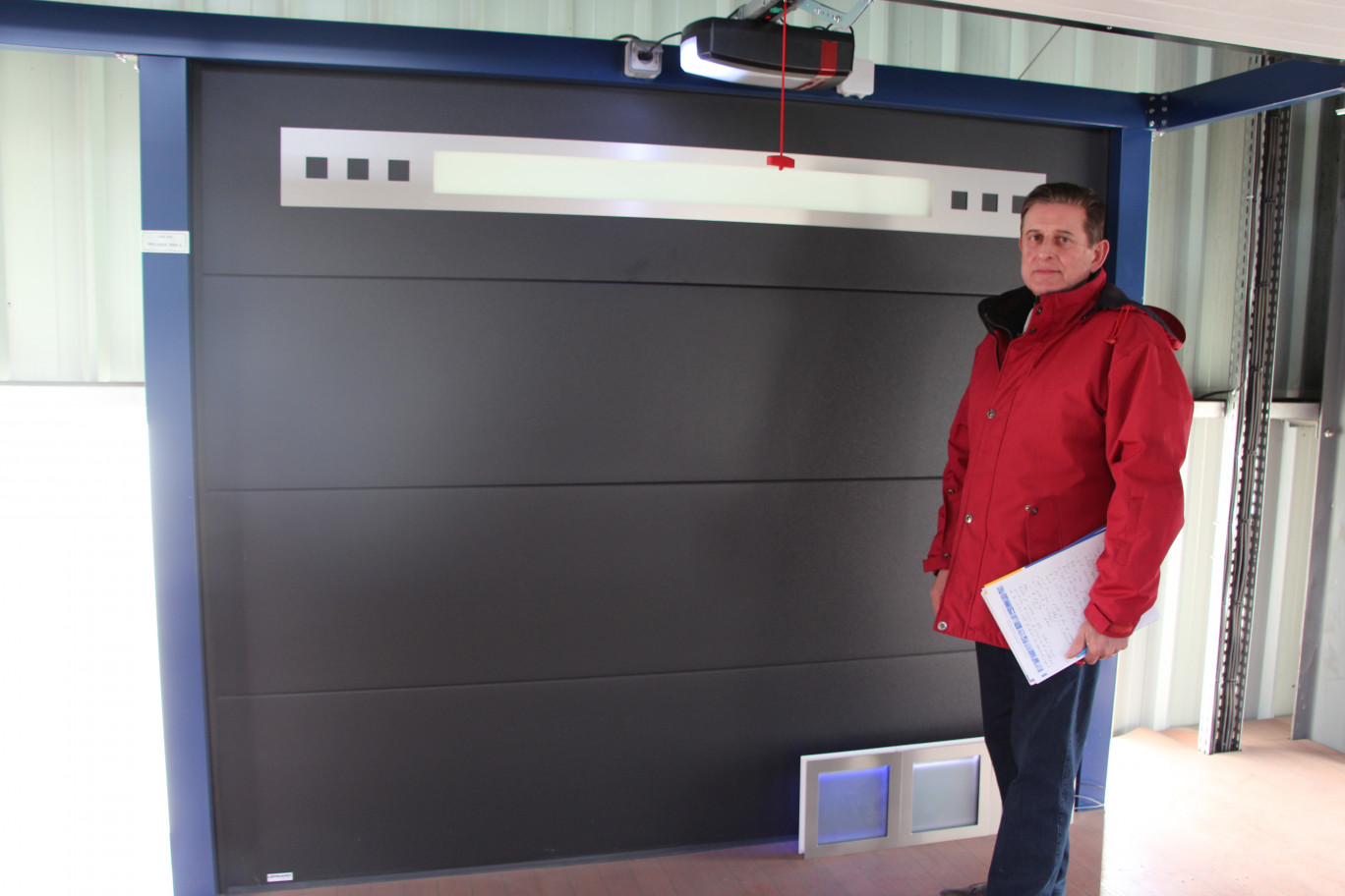 « le directeur Jean-Pierre Batheux devant le hublot horizontal qu'il vient de breveter pour les portes de garage »