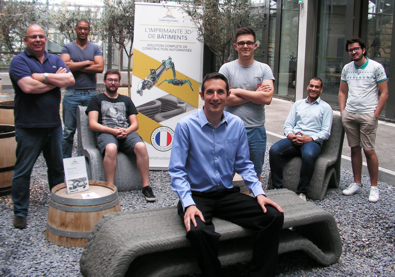 Antoine Motte (au premier plan assis sur un banc réalisé grâce à une imprimante 3D) en compagnie d’une partie de son équipe à la Serre Numérique. De jeunes ingénieurs et un quinquagénaire venu avec son expérience de l’hydraulique dans le BTP.